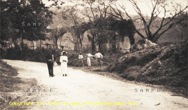 People standing in front of an old aqueduct